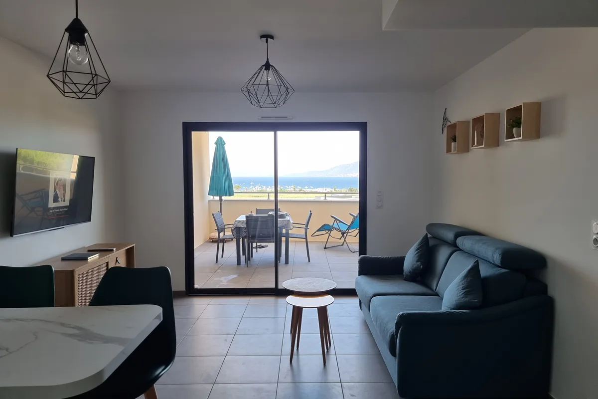 Séjour lumineux avec canapé et vue mer